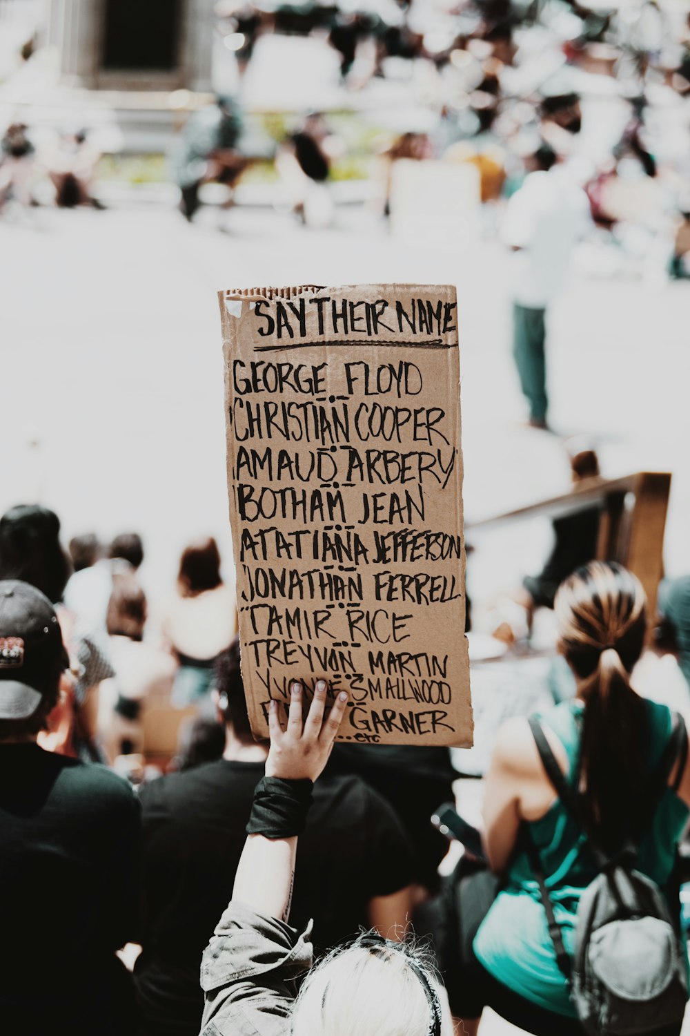 person holding brown wooden quote board