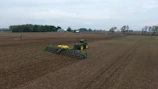 Farm site preparation with machinery smoothing soil for planting.