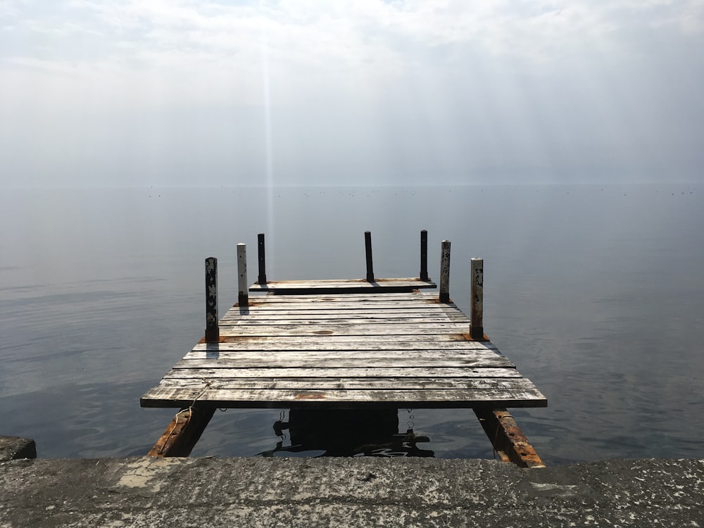 brown wooden dock on body of water during daytime