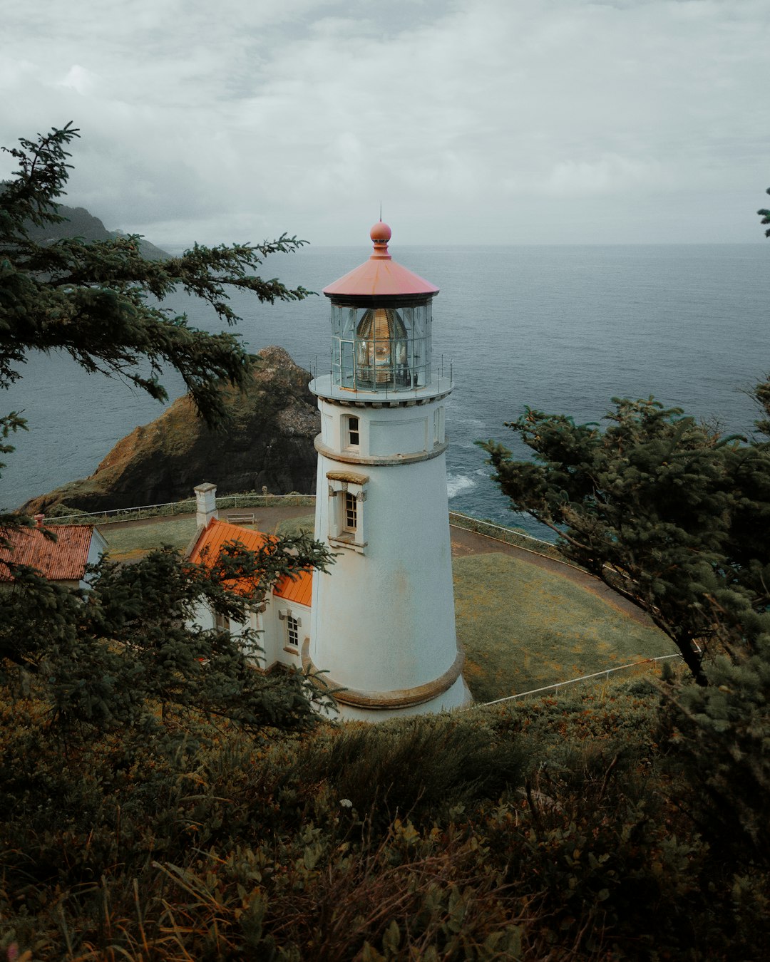 white and red lighthouse near body of water during daytime