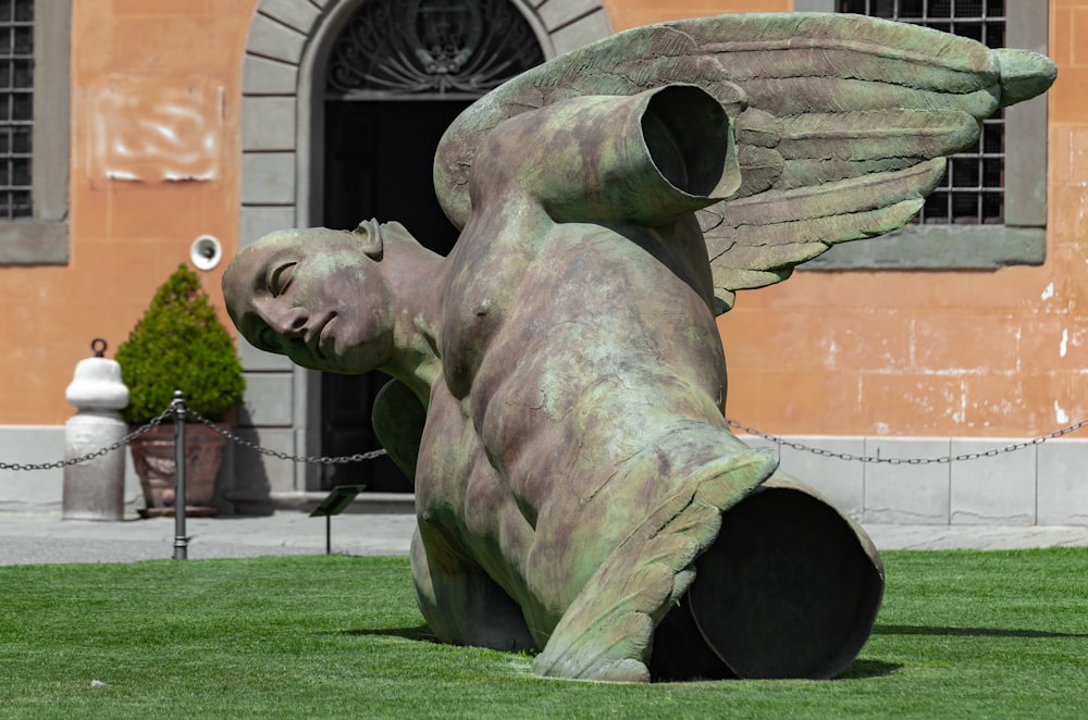 grey concrete statue near brown building during daytime