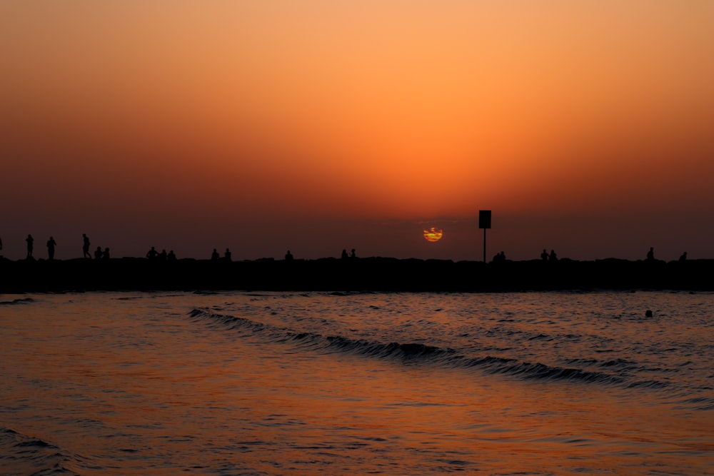 silhouette of building on beach during sunset