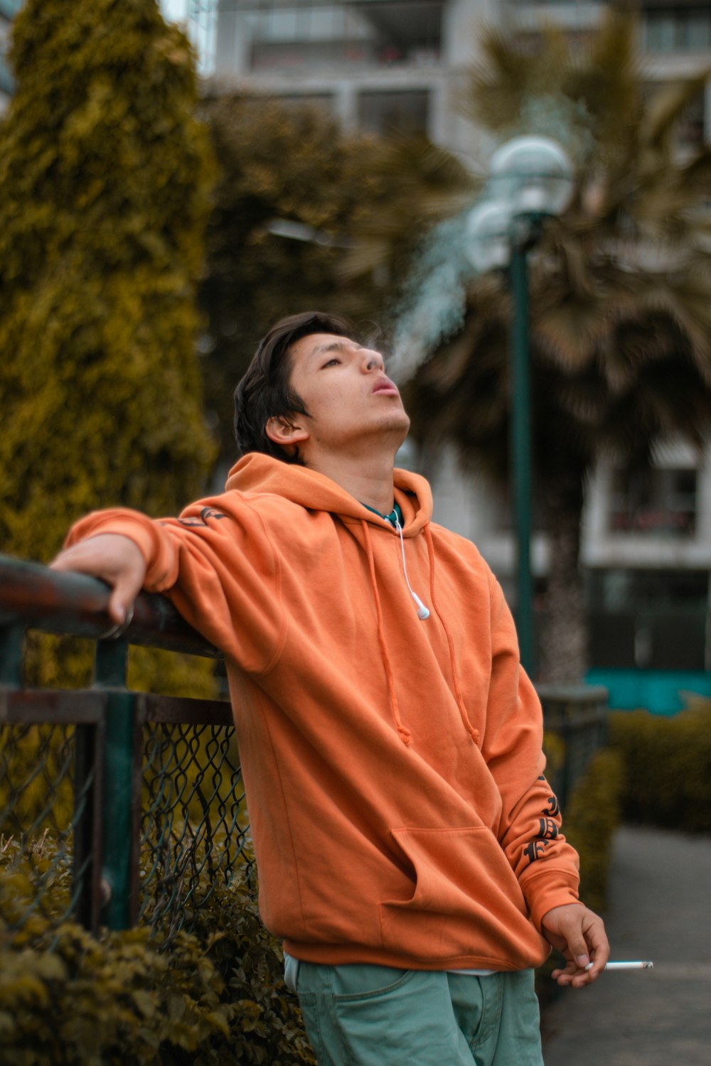 man in orange hoodie smoking