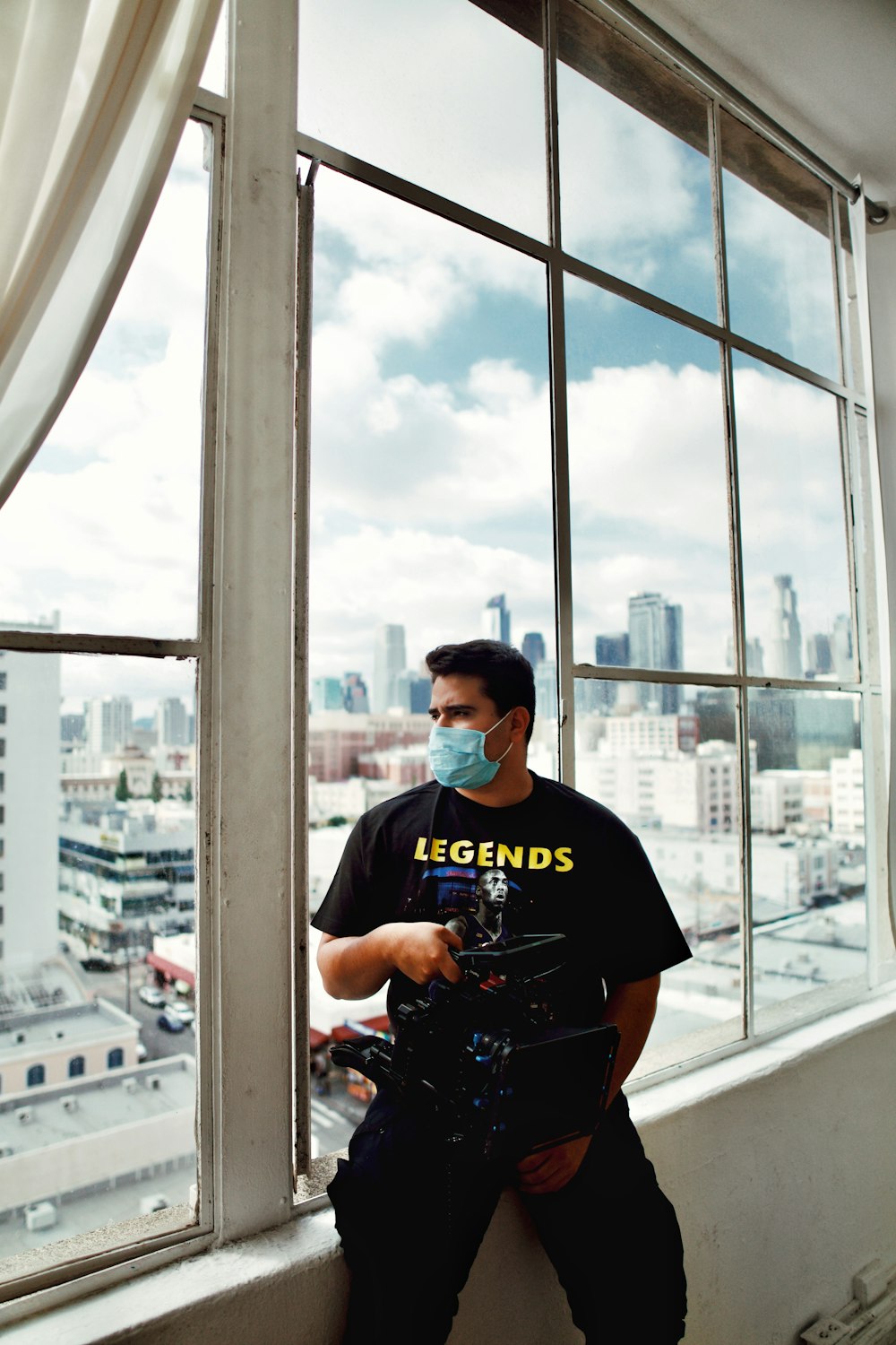 man in black crew neck t-shirt standing near glass window during daytime