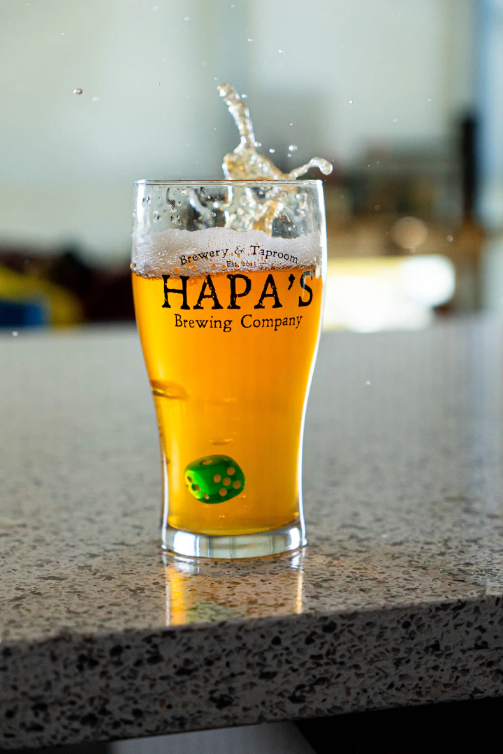 Hazy amber IPA in a clear pint glass, lit warm
