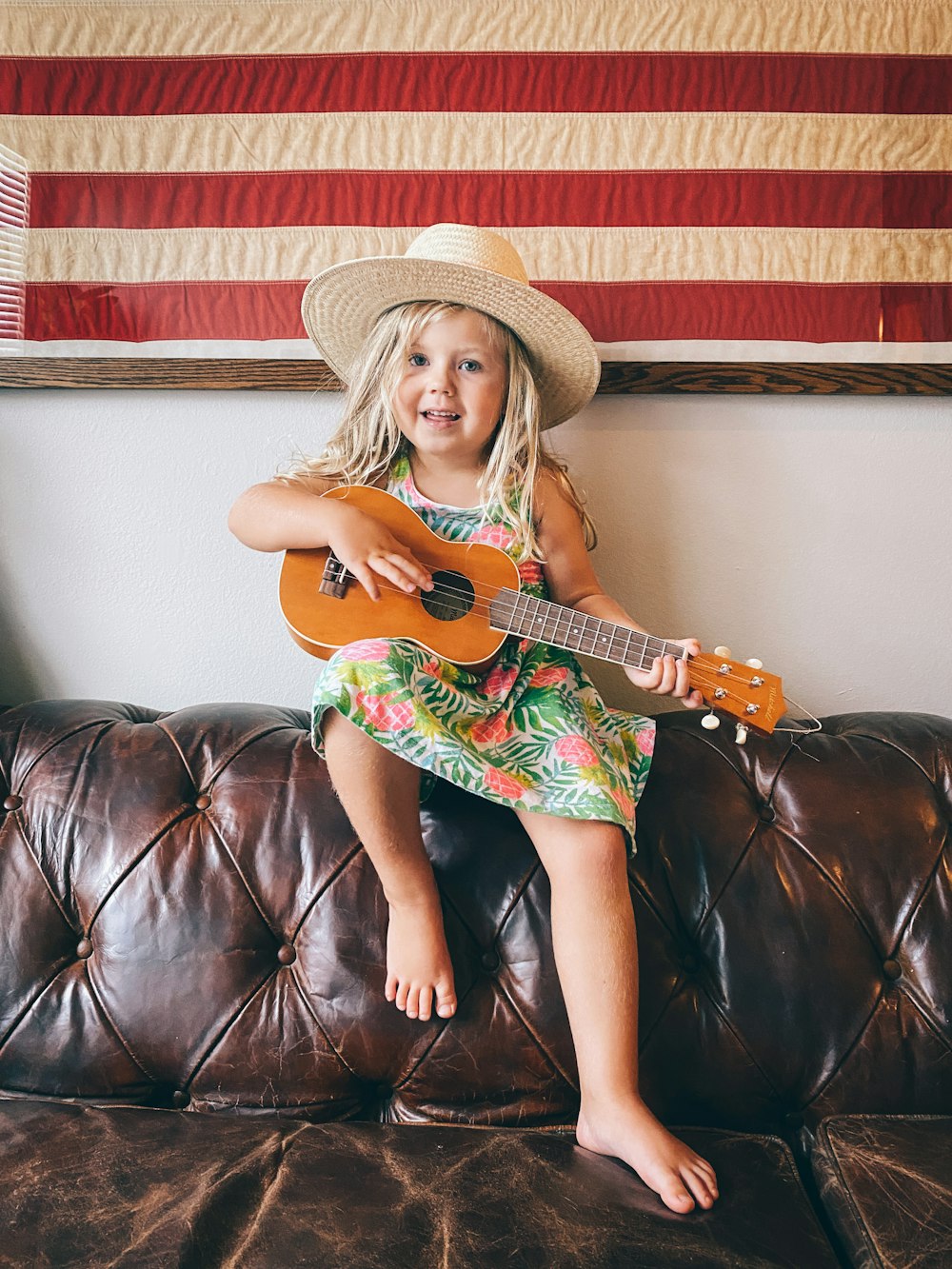 woman in brown cowboy hat and green dress sitting on black leather couch