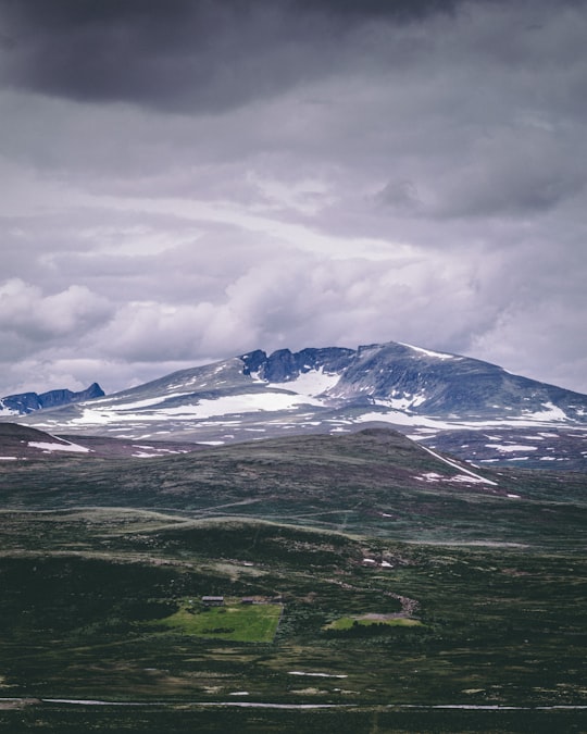 snow covered mountain under cloudy sky during daytime in Viewpoint Snøhetta Norway