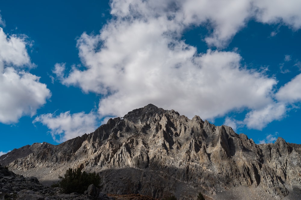 brown rocky mountain under blue sky and white clouds during daytime