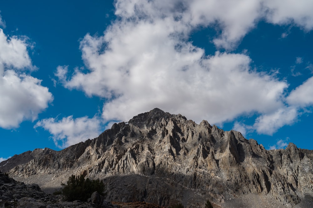 昼間の青空と白い雲の下の茶色の岩山