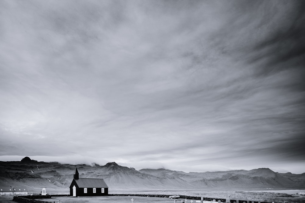 grayscale photo of house on top of hill