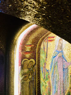 A vibrant, modern grid of Catholic music artist cards with elegant photos and gold accents