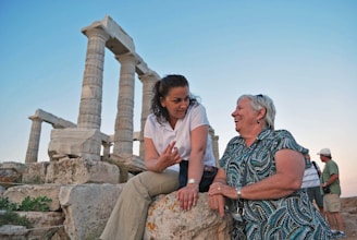 man in white polo shirt sitting beside woman in black and white dress