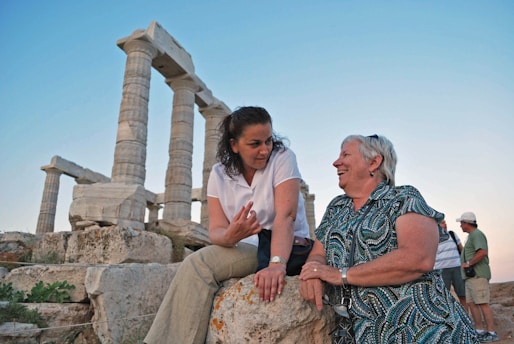 man in white polo shirt sitting beside woman in black and white dress