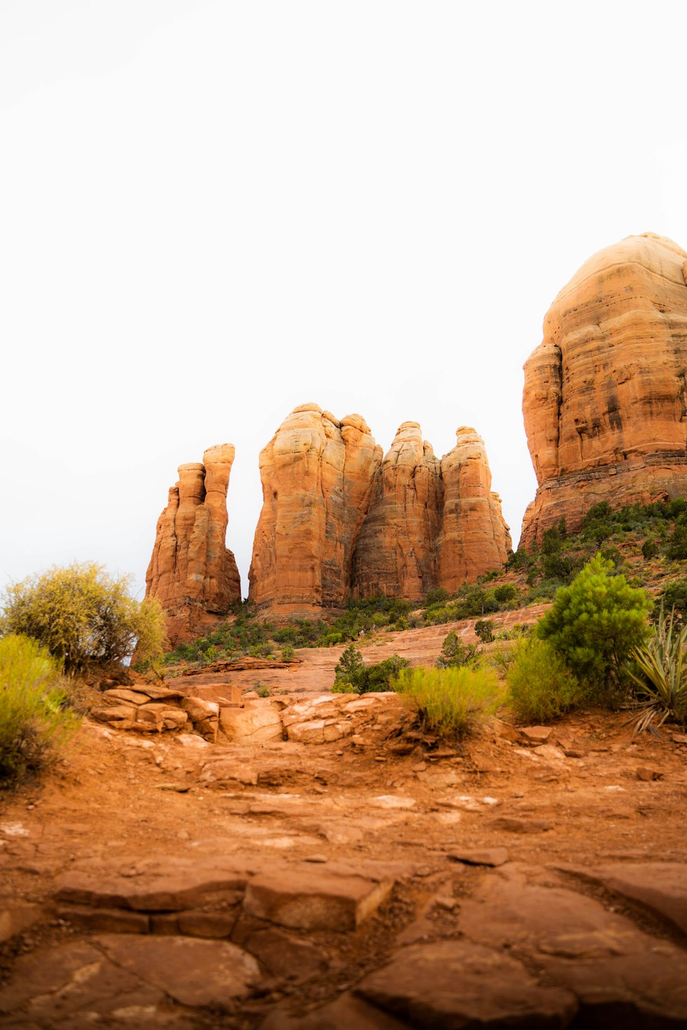 brown rock formation near green grass during daytime