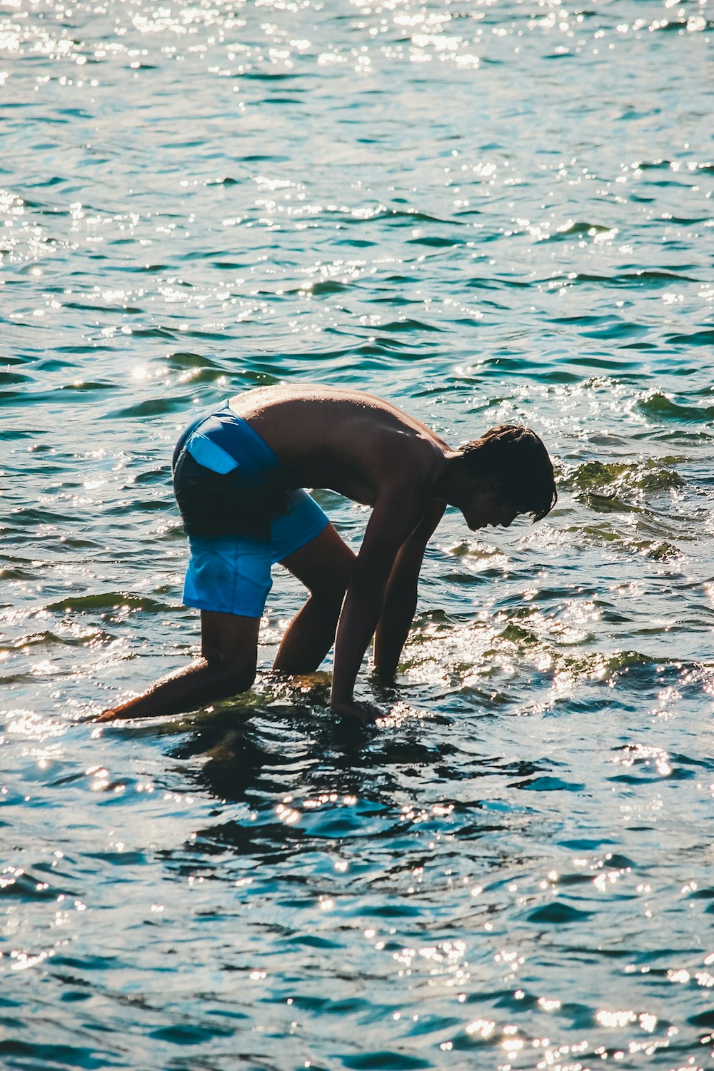 2 men in blue shorts on water during daytime