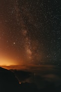 silhouette of mountain under starry night