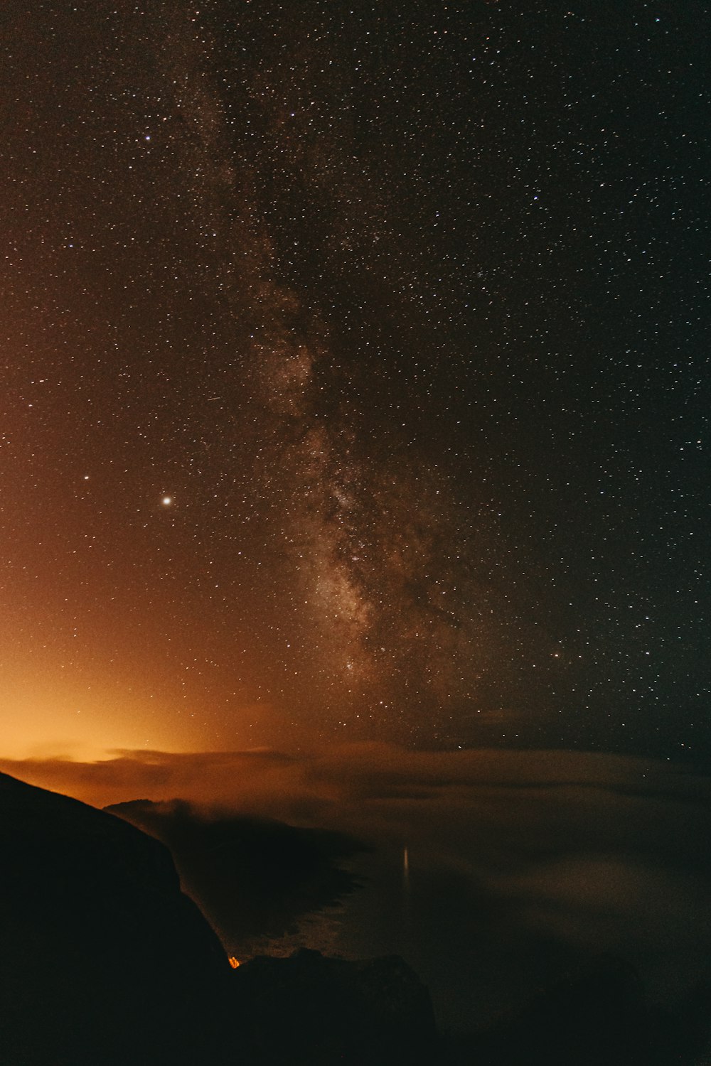 silhouette of mountain under starry night