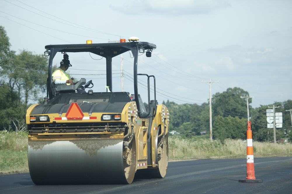 equipamento pesado amarelo e preto na estrada durante o dia