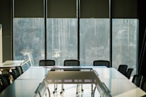 Close-up of a boardroom table with documents and a pen, reflecting governance and discipline.