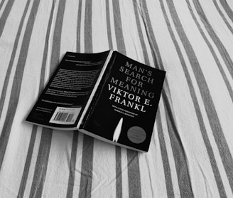 black book on gray and white striped textile