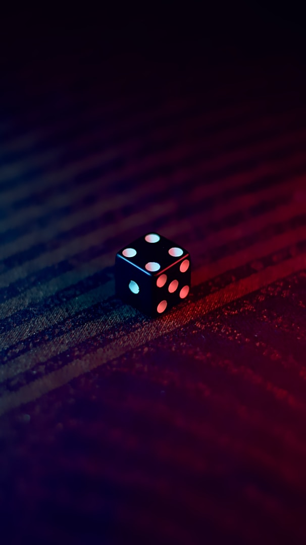 white and black dice on red textile