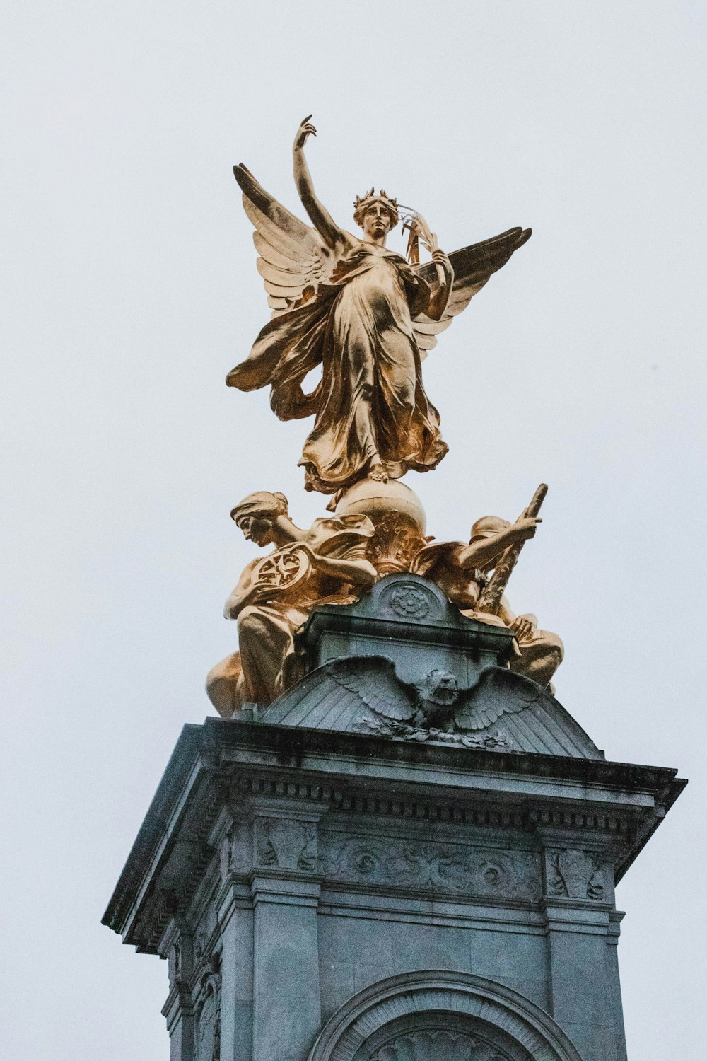 gold statue of man holding book