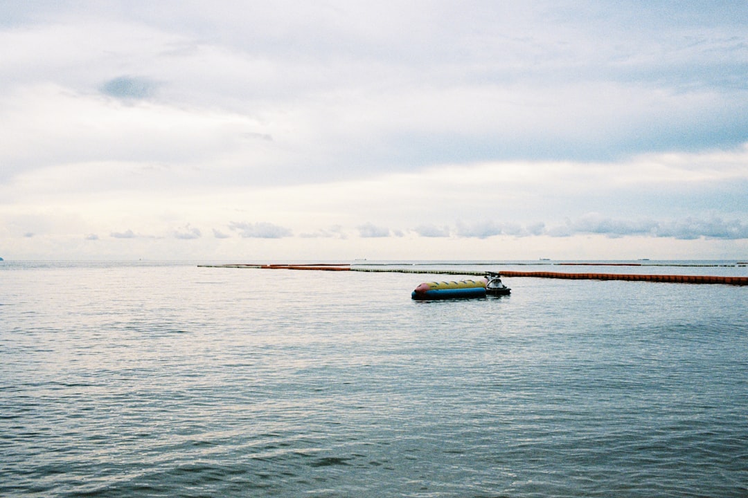 white and blue boat on sea under white clouds during daytime