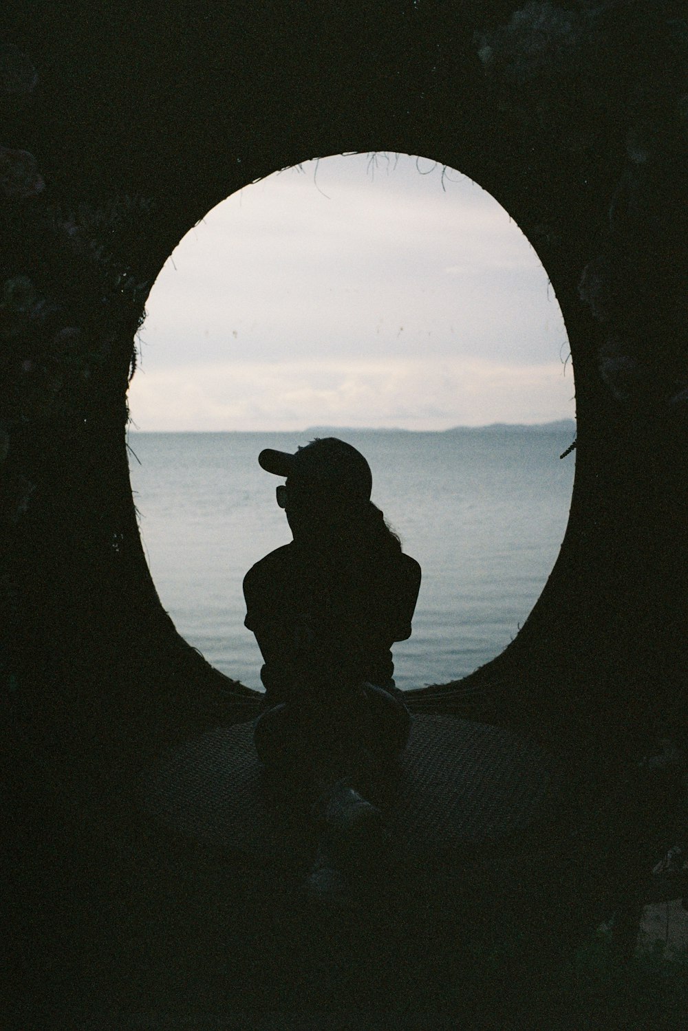 silhouette of man sitting on rock during sunset