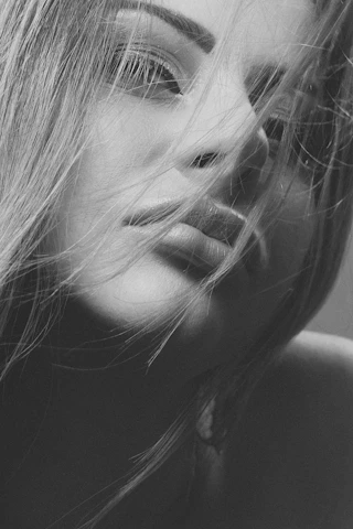 Close-up of a confident woman smiling mysteriously, embodying allure and secrecy.