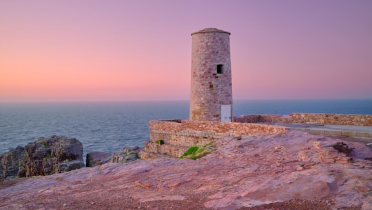 white concrete lighthouse near body of water during daytime in Cap Fréhel France