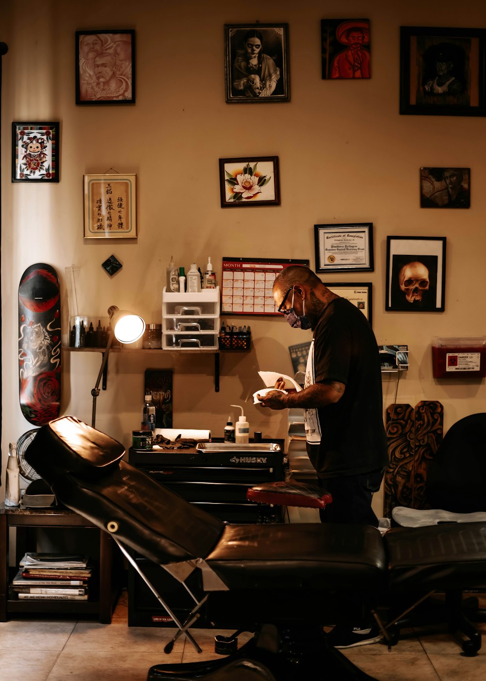 man in black t-shirt standing near brown wooden table