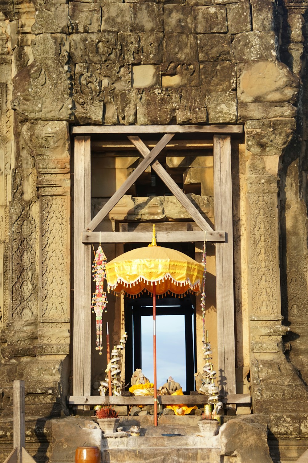 brown wooden framed window with yellow floral curtain