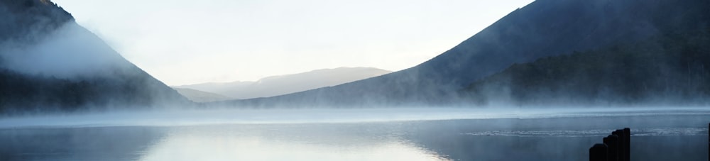 body of water near mountain during daytime