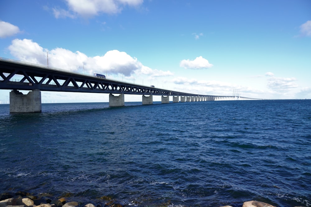 gray bridge over the sea under blue sky during daytime