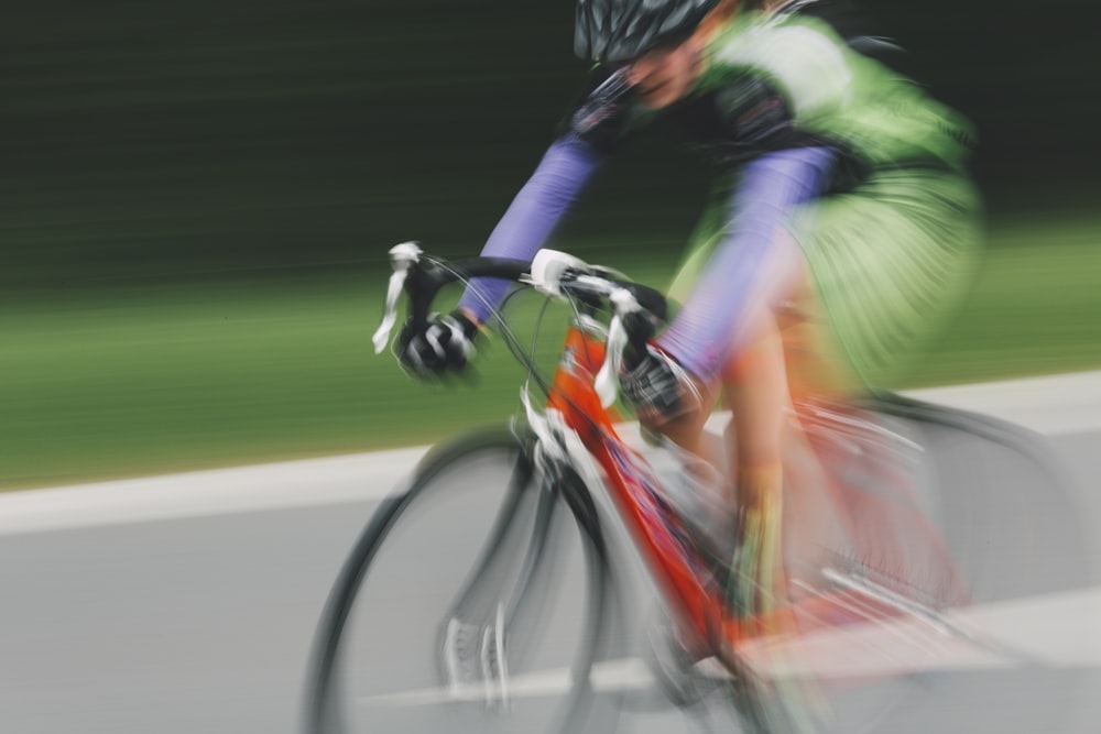 man in green and black jacket riding on bicycle