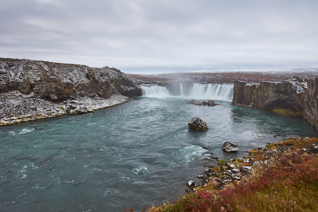 water falls under cloudy sky during daytime