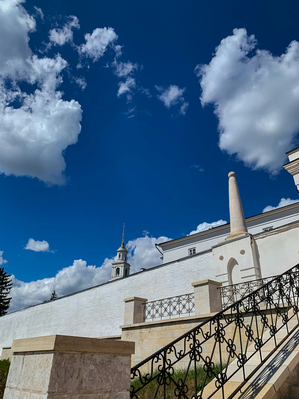 white concrete building under blue sky and white clouds during daytime