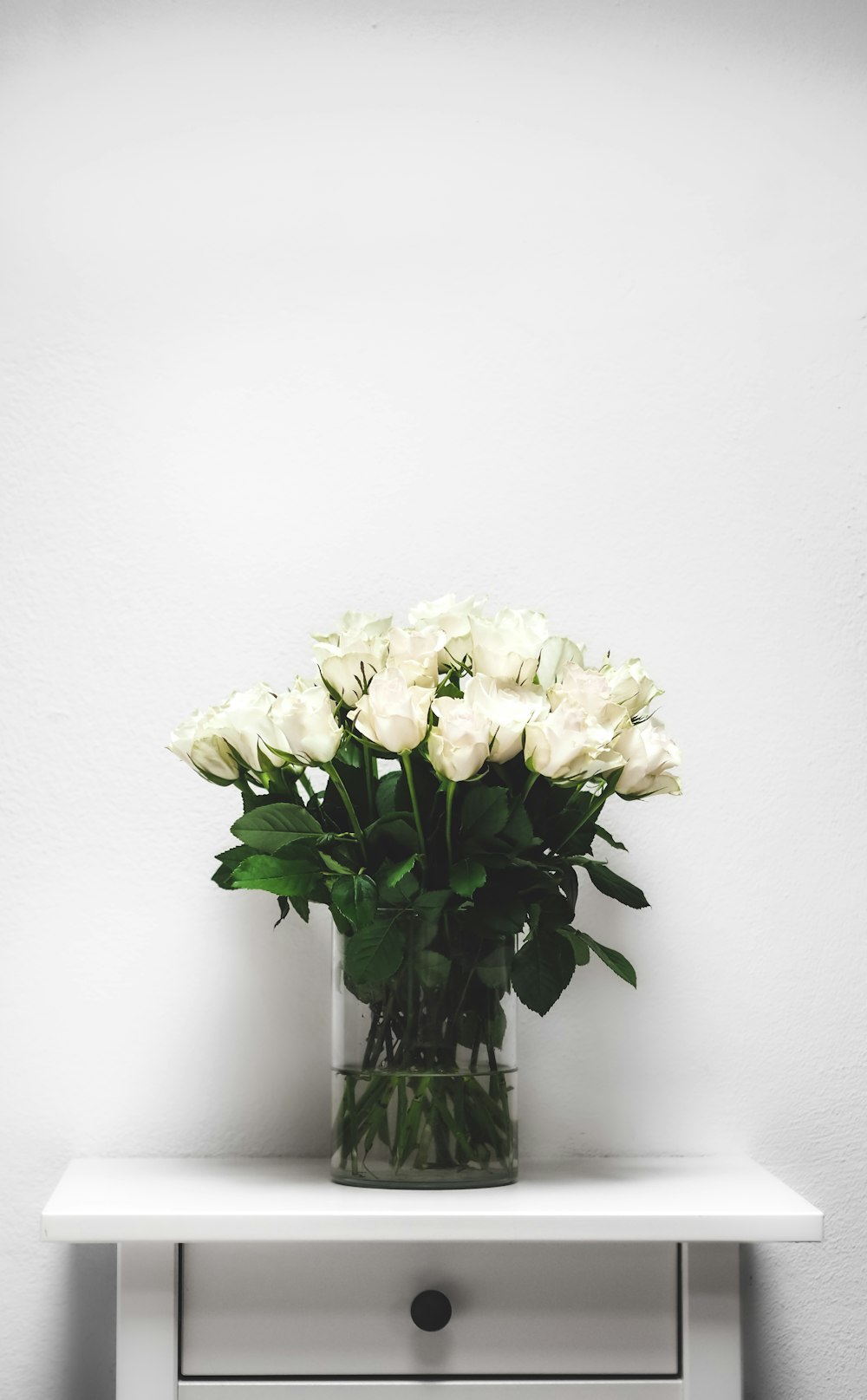 white flowers in clear glass vase