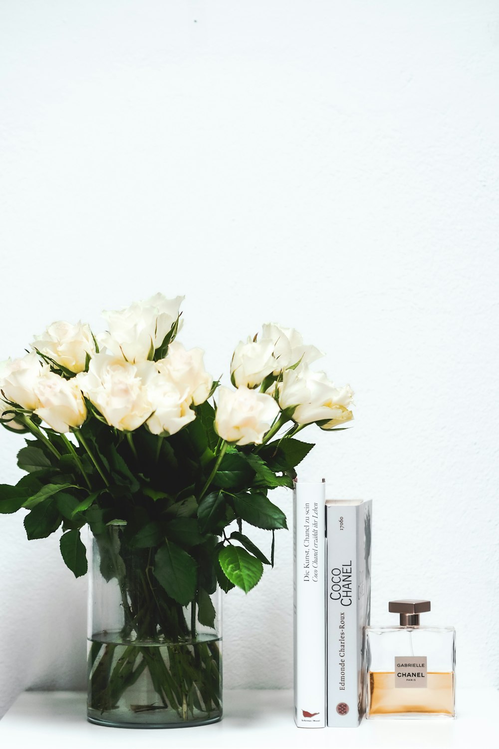 white roses in clear glass vase