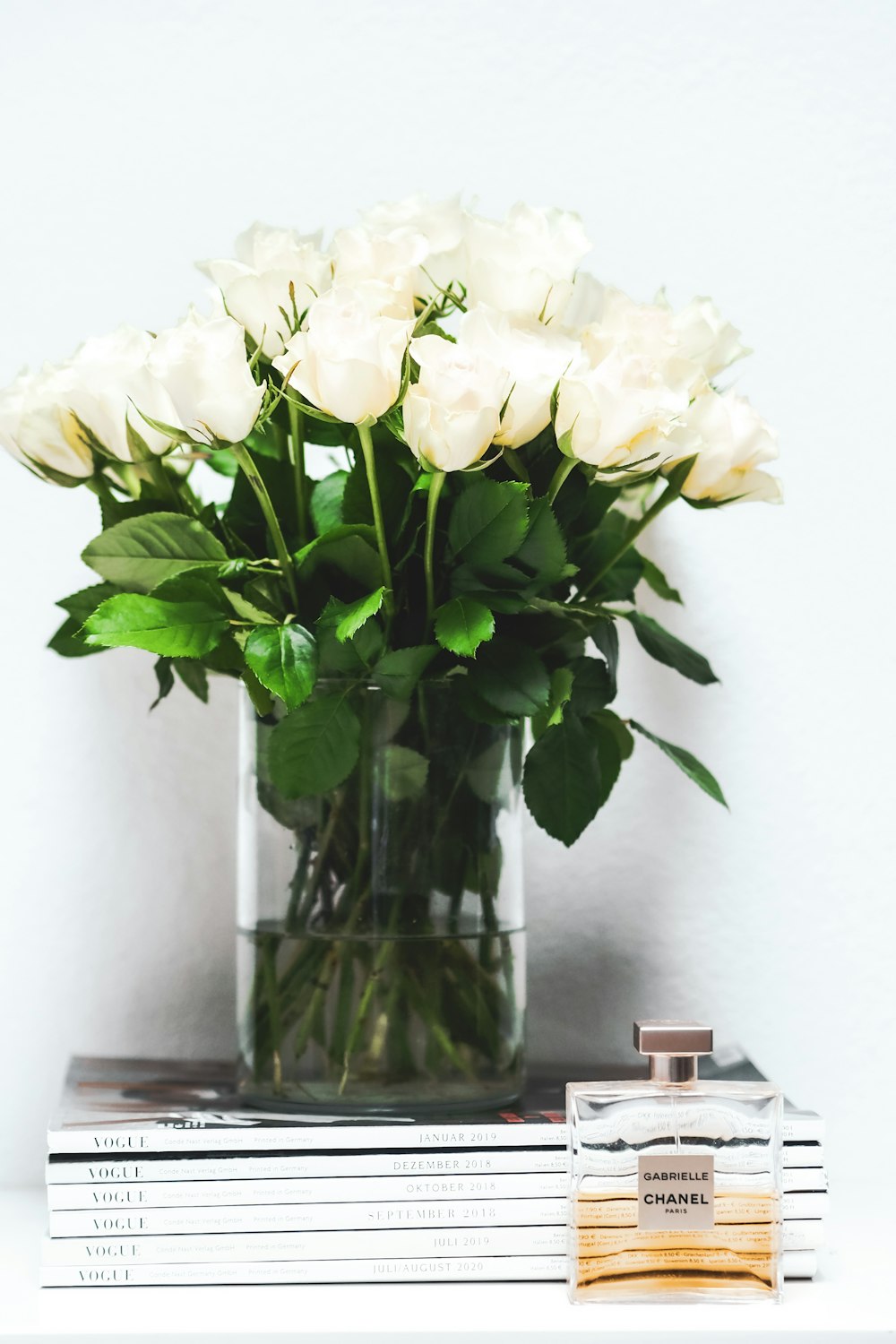 white roses in clear glass vase