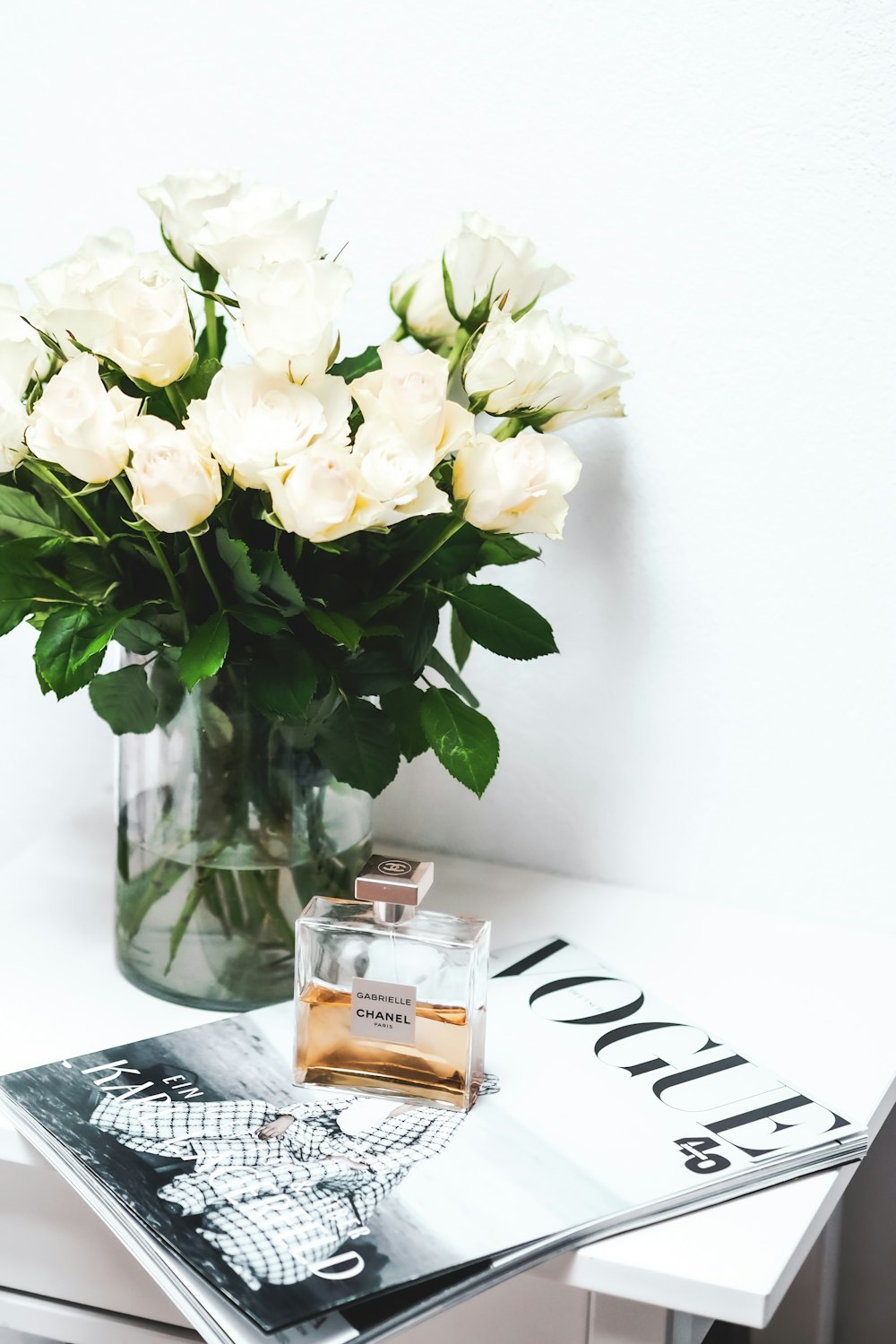 white roses in clear glass vase