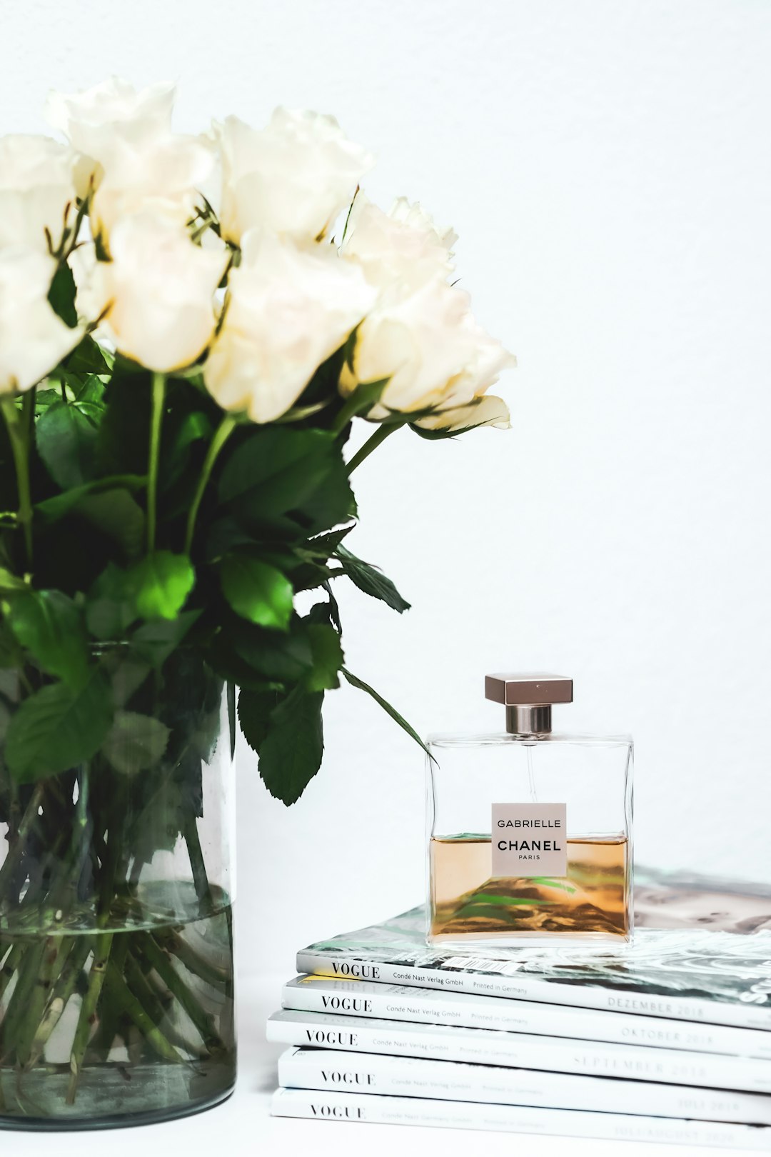 white roses in clear glass vase