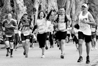 grayscale photo of woman in black tank top running on road