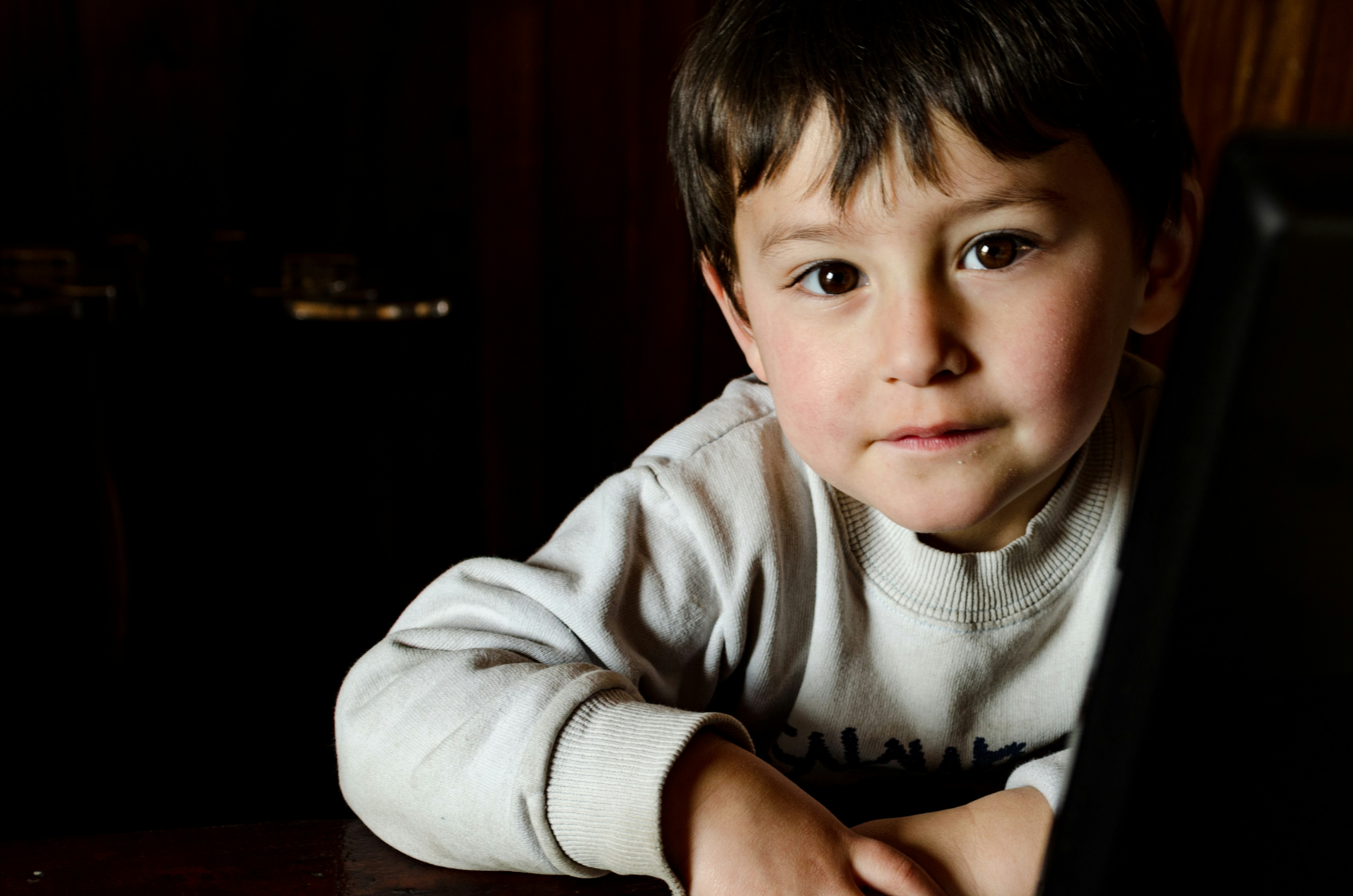 boy in gray sweater sitting on chair