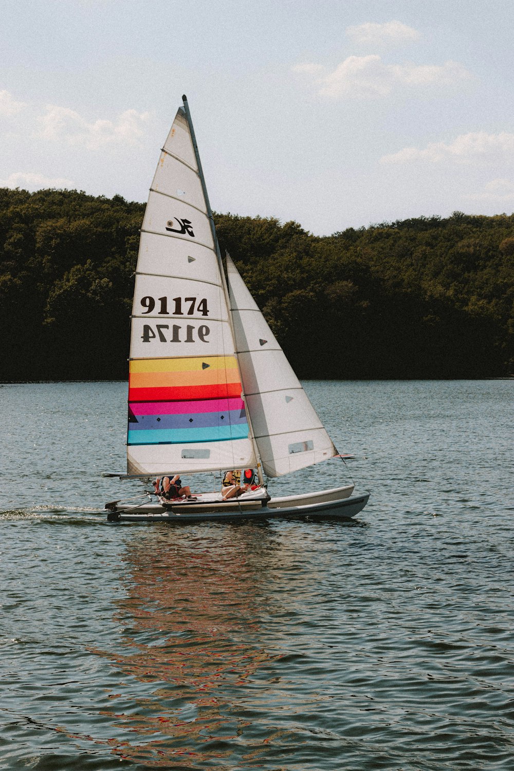 white and red sail boat on body of water during daytime