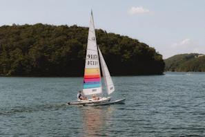 Instructor guiding a guest through basic sailing lessons on calm lake waters