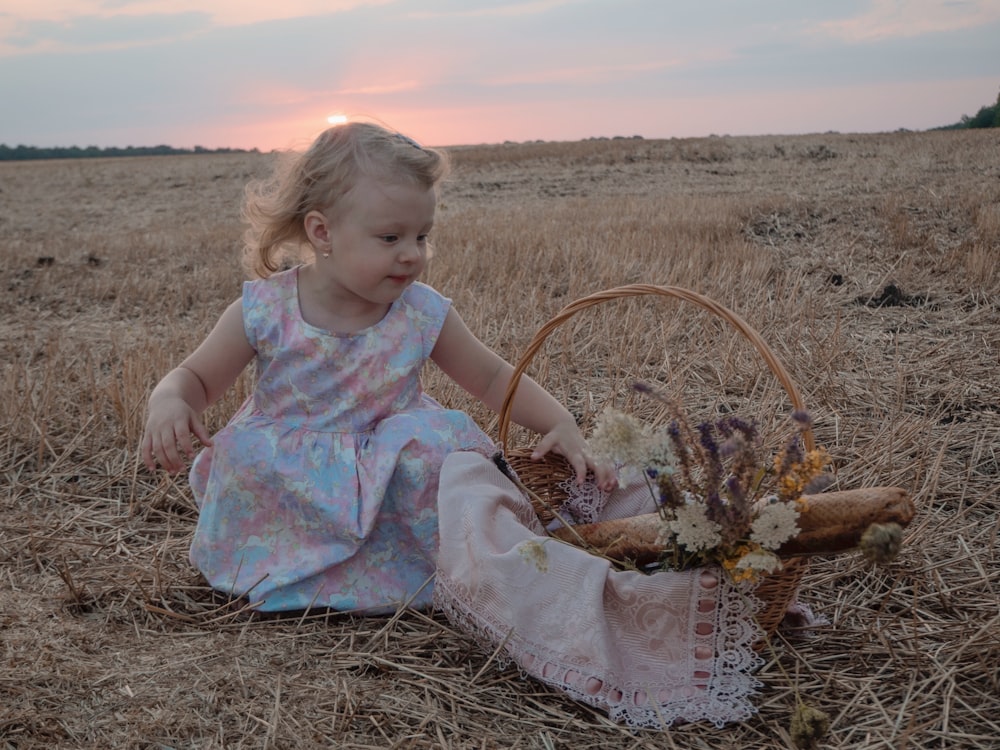 girl in blue dress sitting on brown grass field during daytime