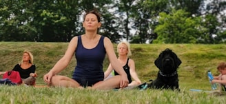 woman in black tank top sitting on green grass field