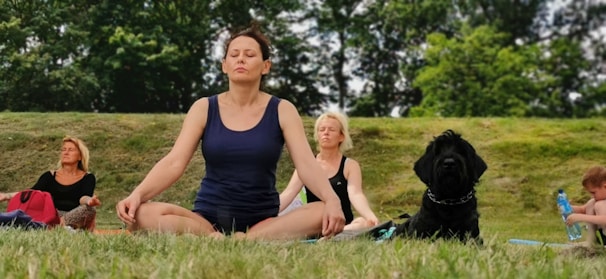 woman in black tank top sitting on green grass field