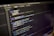 Close-up view of a computer screen displaying a code editor with JavaScript code. The code is color-coded, showing various functions, variables, and comments. The editor interface includes tabs and a menu bar, indicating an active coding session.